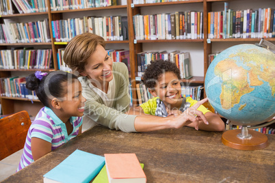 Pupils and teacher looking at globe in library Pupils and teacher looking at globe in library