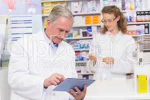 Senior pharmacist using tablet pc