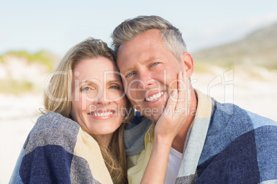 Happy couple wrapped up in blanket