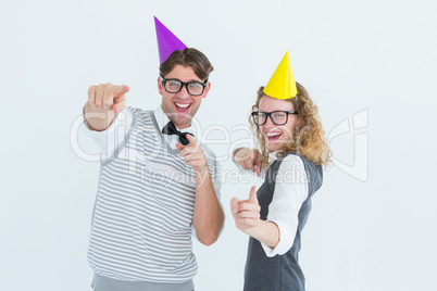 Happy geeky hispser couple dancing with party hat