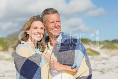 Happy couple wrapped up in blanket