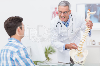 Doctor explaining a spine model to patient