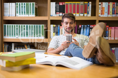 Student listening music in the library with smartphone