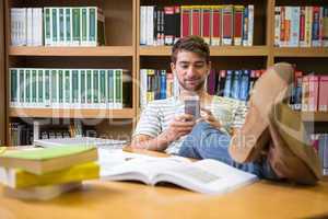 Student listening music in the library with smartphone