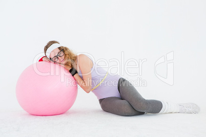 Geeky hipster resting on fitness ball