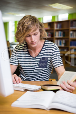 Student studying in the library with computer