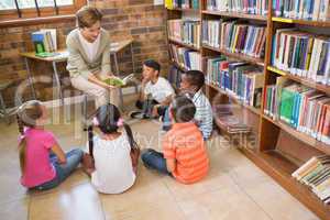 Cute pupils and teacher having class in library