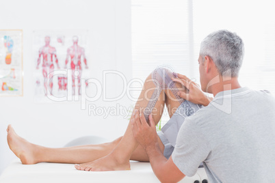 Doctor examining man leg