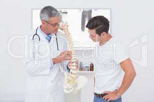 Doctor explaining anatomical spine to his patient