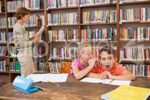 Cute pupils speaking at library