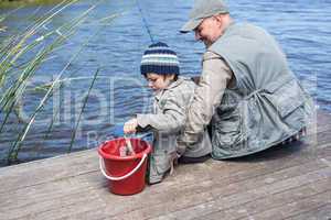 Father and son fihsing at a lake