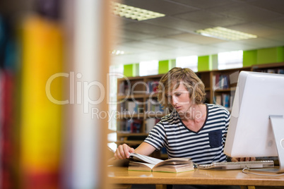 Student studying in the library with computer Student studying in the library with computer