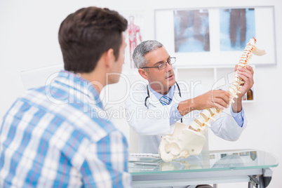 Doctor explaining anatomical spine to his patient Doctor explaining anatomical spine to his patient