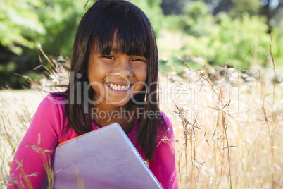 Cute little girl reading in park