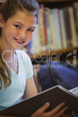 Little girl reading on library floor