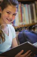 Little girl reading on library floor