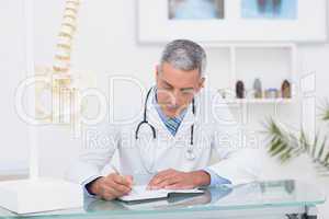 Doctor writing on diary at his desk