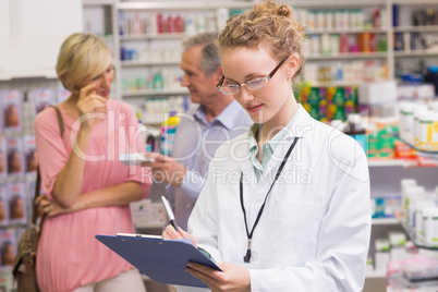 Pharmacist writing on clipboard