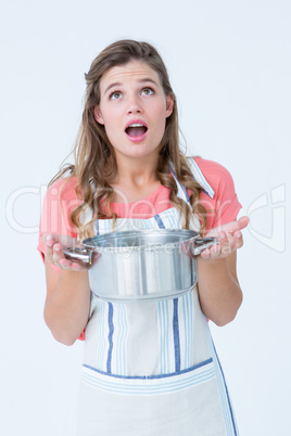 Surprised hipster woman holding pressure cooker