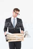 Sad geeky businessman holding box of his things