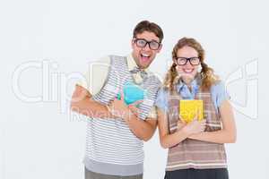 geeky hipster couple holding books and smiling at camera