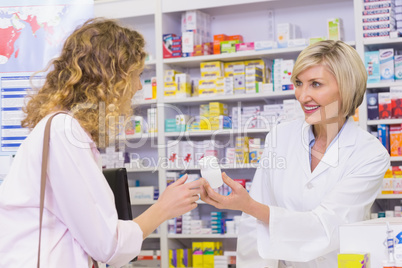 Smiling pharmacist holding a medicine jar