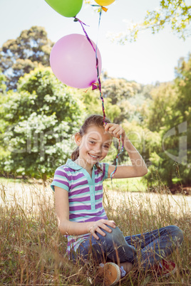Cute little girl holding balloons