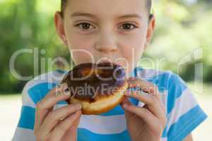 Cute little girl eating doughnut