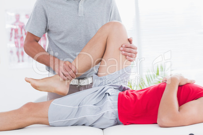 Physiotherapist doing leg massage to his patient