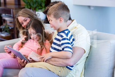 Family on the couch together using tablet pc