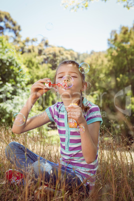 Cute little girl blowing bubbles