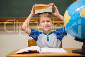 Pupil holding books on his head
