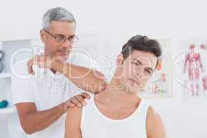 Doctor stretching a young man neck
