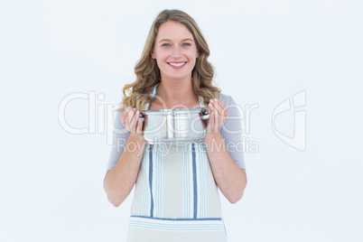 Smiling woman holding saucepan
