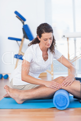 Trainer working with man on exercise mat