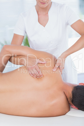 Physiotherapist doing back massage to her patient