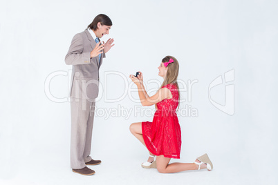 Pretty hipster on bended knee doing a marriage proposal to her b