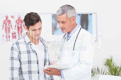 Doctor showing clipboard to his patient