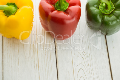Three peppers on chopping board