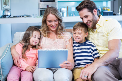 Happy family on the couch together using tablet