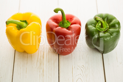 Three peppers on chopping board Three peppers on chopping board
