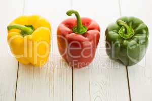 Three peppers on chopping board