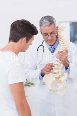 Doctor explaining anatomical spine to his patient Doctor explaining anatomical spine to his patient