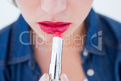 Woman putting red lipstick
