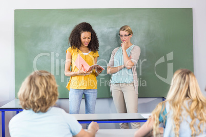 Student explaining notes besides teacher in class