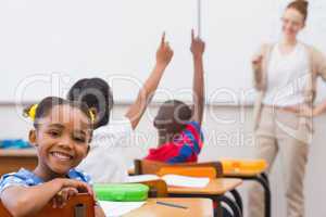 Cute pupil smiling at camera in classroom