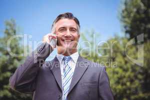 Businessman using phone in the park