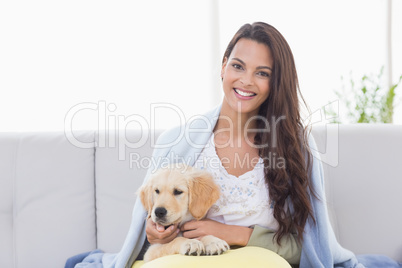 Portrait of woman playing with puppy