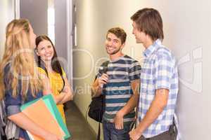 Students with files standing at college corridor