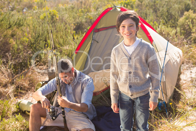 Father and son beside their tent in the countryside